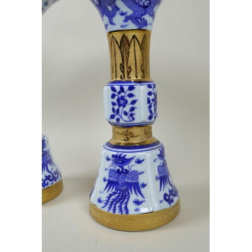 188 - A pair of Chinese blue and white gu shaped vases with banded gilt highlights, and decorated with pho... 