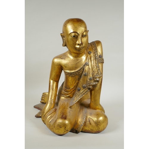 19 - A carved and gilt Thai figure of a seated Buddha, the robes set with decorative stones, 40cm high