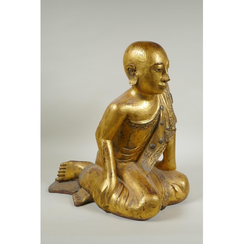 19 - A carved and gilt Thai figure of a seated Buddha, the robes set with decorative stones, 40cm high