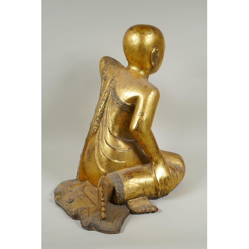 19 - A carved and gilt Thai figure of a seated Buddha, the robes set with decorative stones, 40cm high