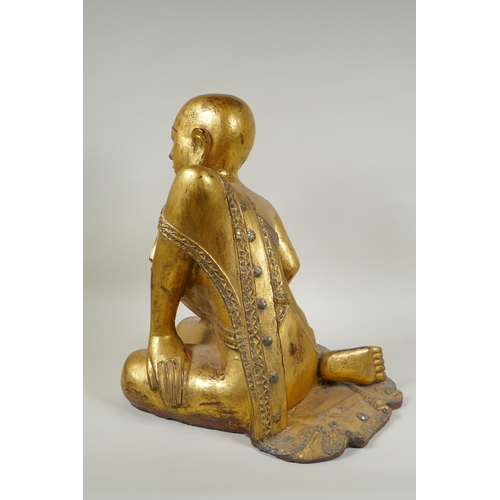 19 - A carved and gilt Thai figure of a seated Buddha, the robes set with decorative stones, 40cm high