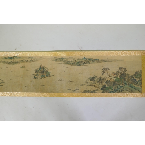 193 - A Chinese printed watercolour scroll depicting an extensive riverside landscape, 29cm high