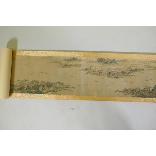 193 - A Chinese printed watercolour scroll depicting an extensive riverside landscape, 29cm high