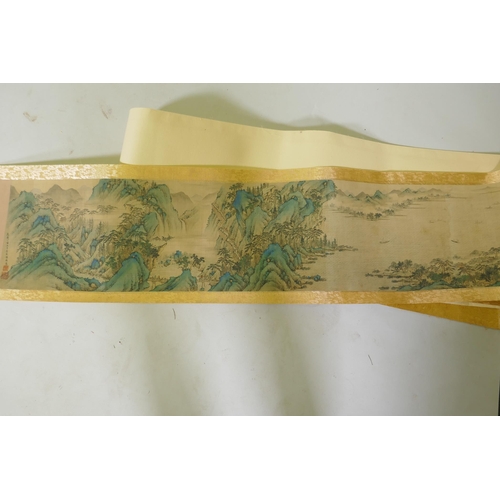 193 - A Chinese printed watercolour scroll depicting an extensive riverside landscape, 29cm high