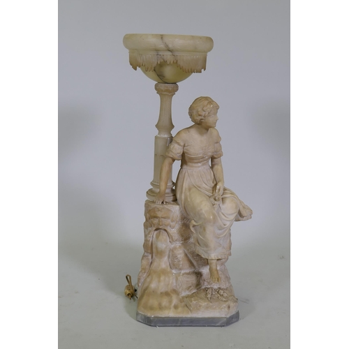 197 - An early C20th alabaster lamp in the form of a young woman seated upon a rock, on a marble base sign... 