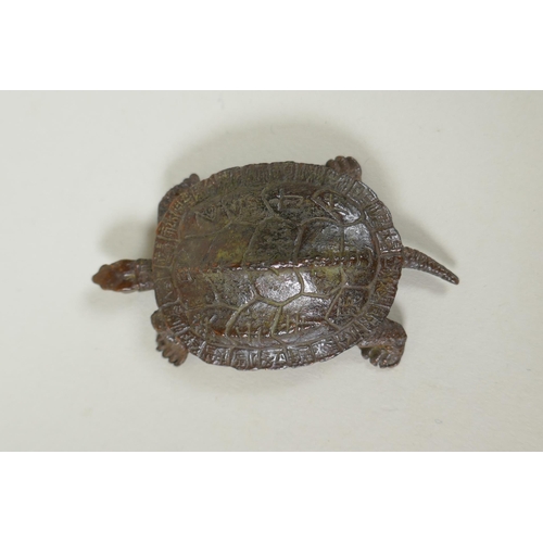 221 - A Japane4se style bronze okimono tortoise, the shell with character inscriptions, 7cm long