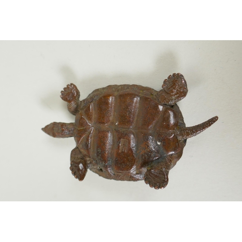 221 - A Japane4se style bronze okimono tortoise, the shell with character inscriptions, 7cm long