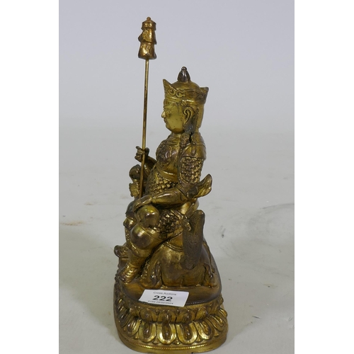 222 - A Chinese gilt bronze figure of a deity seated on a dragon, 26cm high