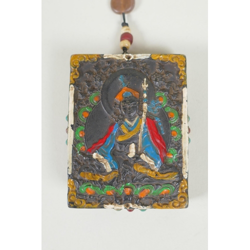 225 - A Tibetan carved and painted hardstone tablet depicting a deity, the reverse set with abalone, dzi b... 