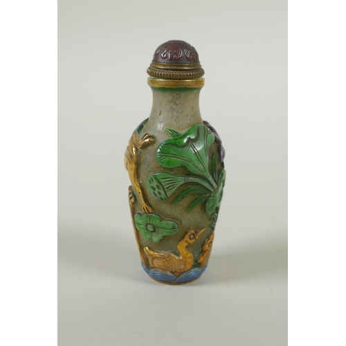 226 - A Peking glass snuff bottle with carved and enamelled decoration of frogs, waterfowl and lotus flowe... 