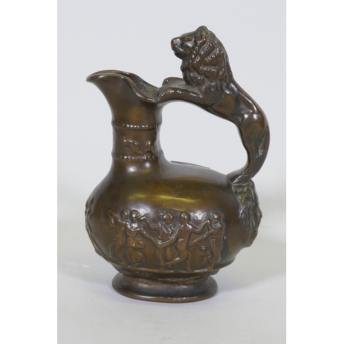 229 - An antique cast bronze pitcher, with raised Bacchanalian decoration and lion handle, 23cm high