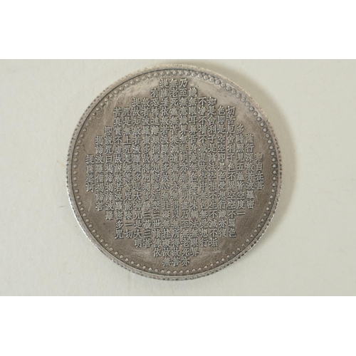 230 - A Tibetan white metal token decorated with a tanka depiction and character inscription verso, 4cm di... 