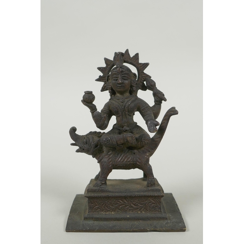 24 - An antique Indian bronze figure of Durga riding a mythical creature, 12cm high