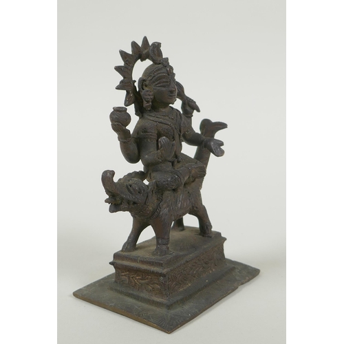 24 - An antique Indian bronze figure of Durga riding a mythical creature, 12cm high