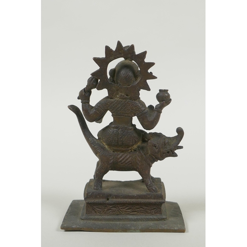 24 - An antique Indian bronze figure of Durga riding a mythical creature, 12cm high