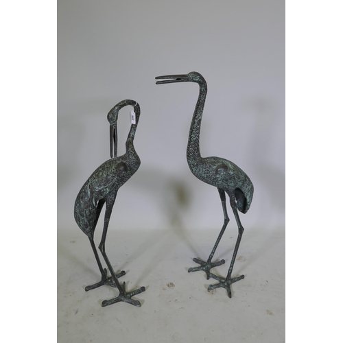 258 - A pair of metal garden cranes with green patina, 81cm high