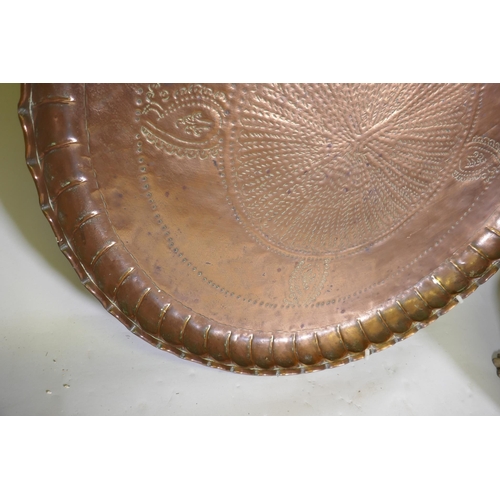 57 - A large Indo/Persian copper tray, 64cm wide, and a brass tray with Islamic calligraphy decoration