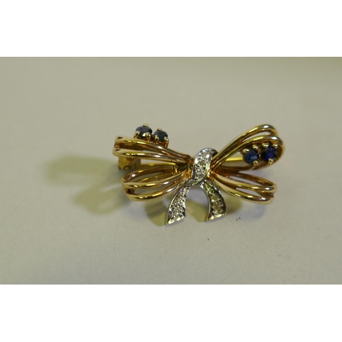 610 - A 9ct gold bow shaped brooch inset with diamonds, 2.5cm wide, 3.6g