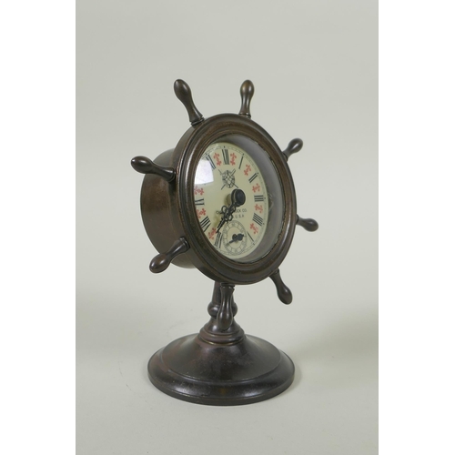 616 - A bronze desk clock in the form of a ship's wheel, the dial with Roman numerals and smaller subsidia... 