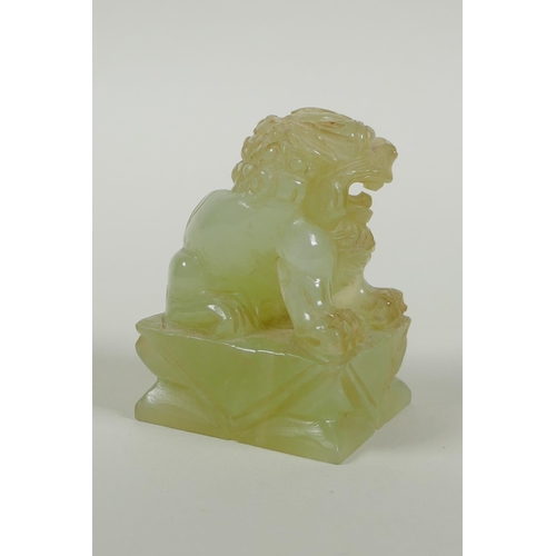 65 - A Chinese carved green jade temple lion, 7cm high