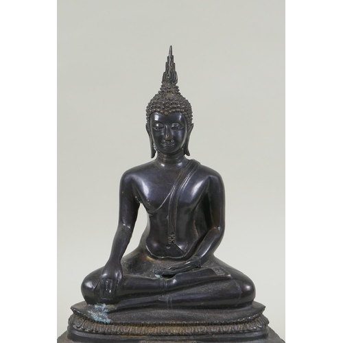 69 - A Thai bronze figure of Buddha seated on a tiered throne,