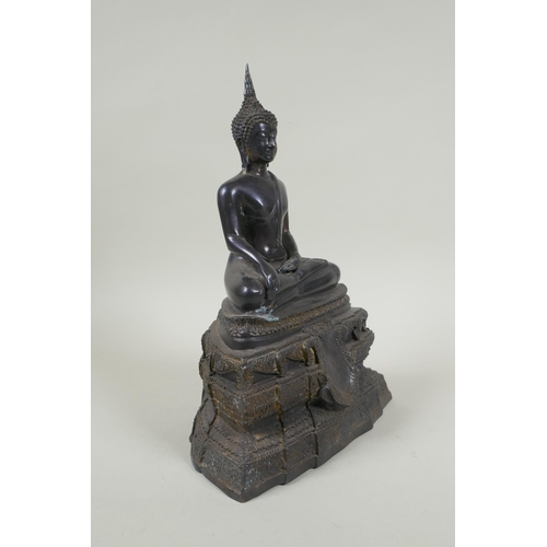 69 - A Thai bronze figure of Buddha seated on a tiered throne,