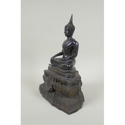 69 - A Thai bronze figure of Buddha seated on a tiered throne,