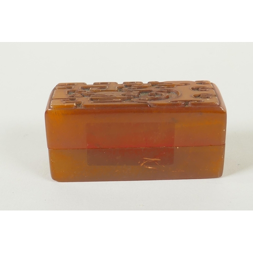 78 - A Chinese amber soapstone seal and matching box with carved archaic dragon decorated to the cover, c... 