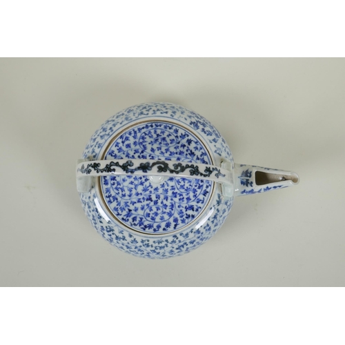 80 - An early C20th Japanese blue and white porcelain tea pot of squat form, with all over scrolling vine... 