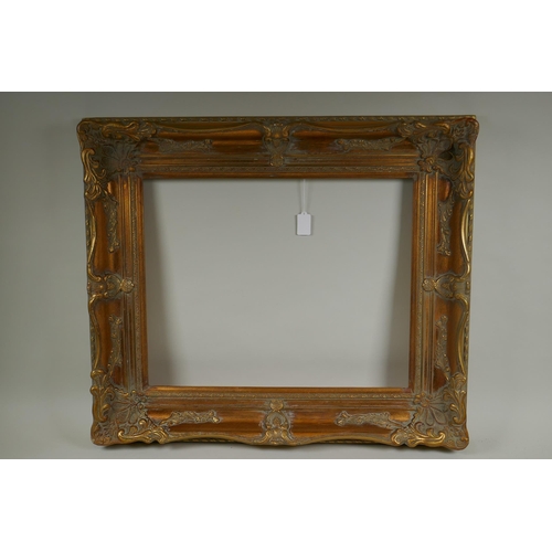 811 - A C20th gilt picture frame with scroll and floret decoration, rebate 51 x 41cm