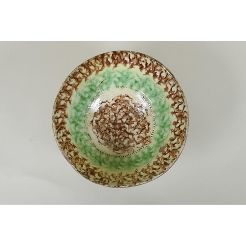 91 - An Islamic earthenware bowl with sponged decoration, 21cm diameter