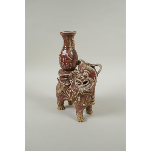 93 - A Chinese flambe glazed porcelain spill vase in the form of a temple lion, 23cm high