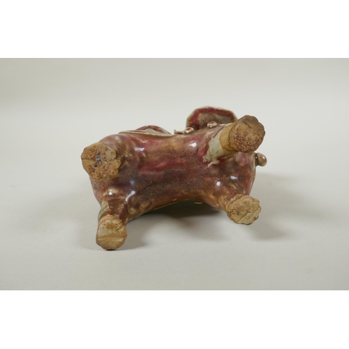 93 - A Chinese flambe glazed porcelain spill vase in the form of a temple lion, 23cm high