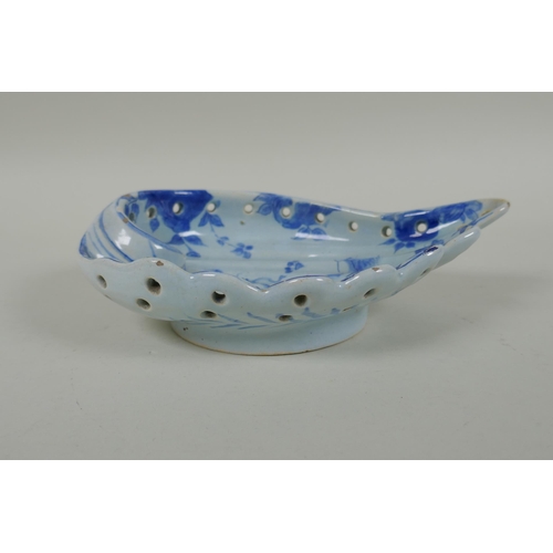 99 - An antique Cantagalli faience blue and white shell shaped dish with putto decoration, 21 x 14cm