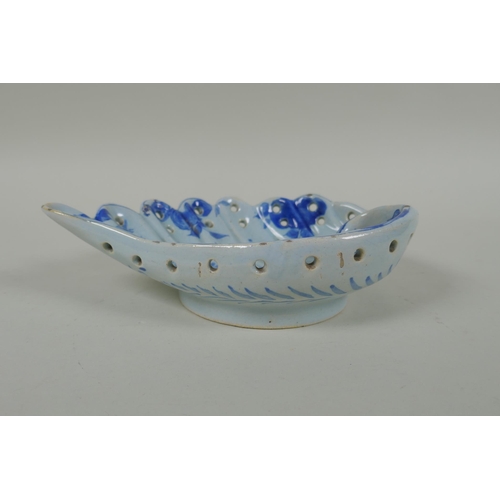 99 - An antique Cantagalli faience blue and white shell shaped dish with putto decoration, 21 x 14cm