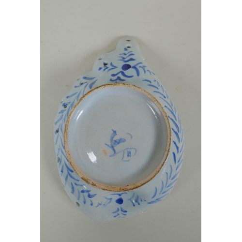 99 - An antique Cantagalli faience blue and white shell shaped dish with putto decoration, 21 x 14cm