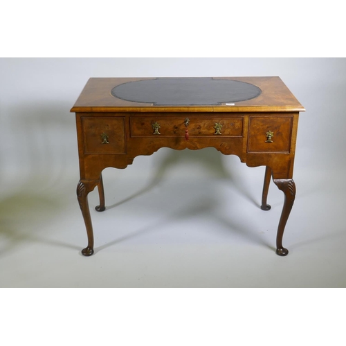 1002 - A Georgian style walnut kneehole desk, with leather inset top over three drawers and shaped apron, r... 