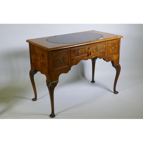 1002 - A Georgian style walnut kneehole desk, with leather inset top over three drawers and shaped apron, r... 