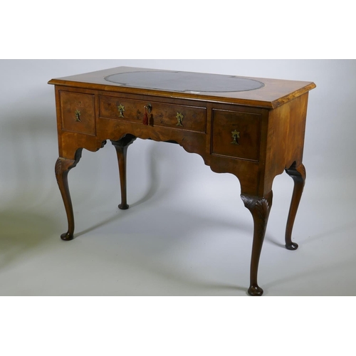 1002 - A Georgian style walnut kneehole desk, with leather inset top over three drawers and shaped apron, r... 