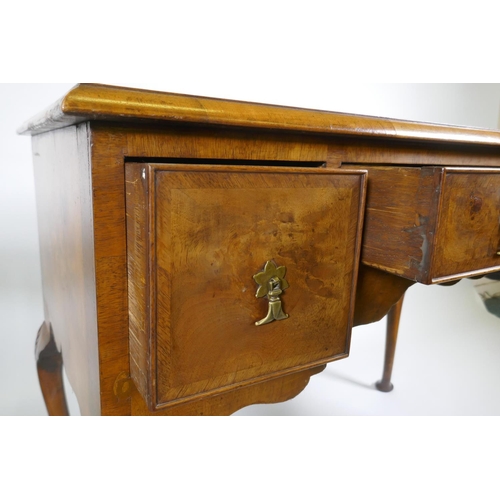 1002 - A Georgian style walnut kneehole desk, with leather inset top over three drawers and shaped apron, r... 