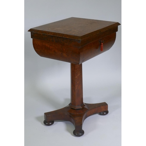 1003 - A Victorian oak workbox, the lift up top with fitted interior, raised on a tapering column and platf... 