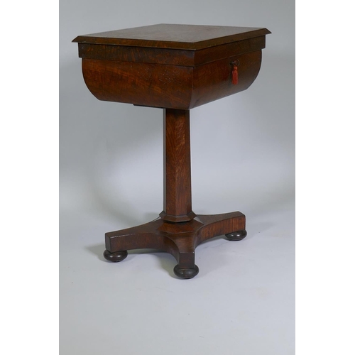 1003 - A Victorian oak workbox, the lift up top with fitted interior, raised on a tapering column and platf... 