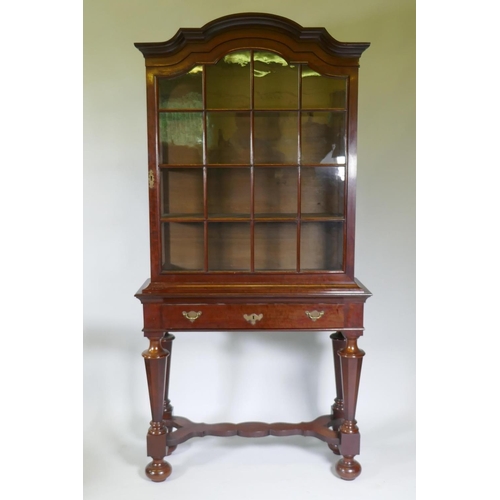 1005 - A C19th Dutch mahogany dome topped glazed display cabinet, with single door on a base with one long ... 