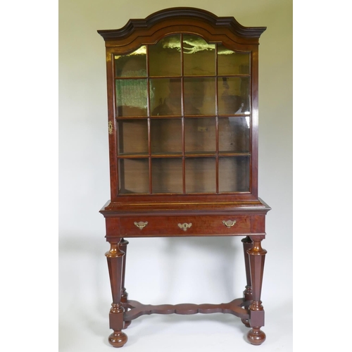 1005 - A C19th Dutch mahogany dome topped glazed display cabinet, with single door on a base with one long ... 