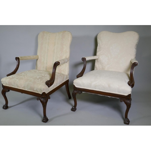 1012 - A pr of C18th style Gainsborough chairs with carved decoration and hump backs, raised on cabriole su... 