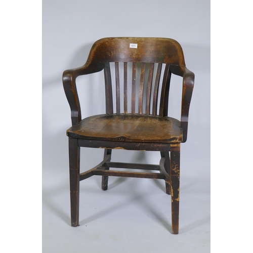 1017 - An early C20th oak office desk arm chair with shaped seat and slatted back