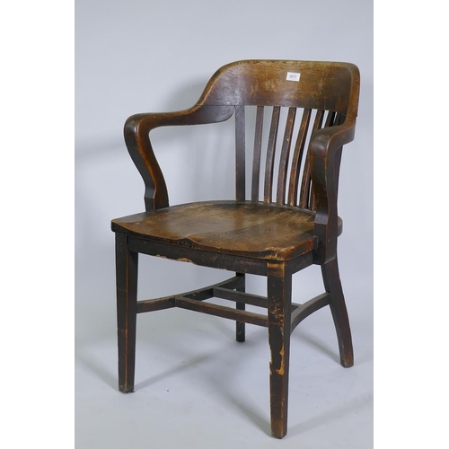 1017 - An early C20th oak office desk arm chair with shaped seat and slatted back