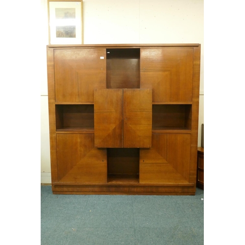 1029 - A Continental mid century rosewood cabinet with four doors around an open shelf and cupboards reveal... 