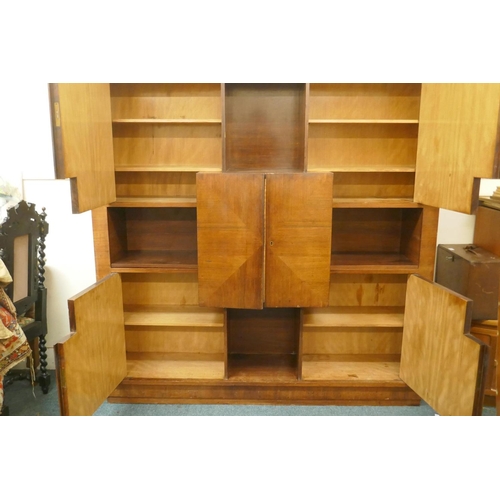 1029 - A Continental mid century rosewood cabinet with four doors around an open shelf and cupboards reveal... 