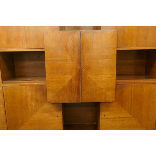 1029 - A Continental mid century rosewood cabinet with four doors around an open shelf and cupboards reveal... 